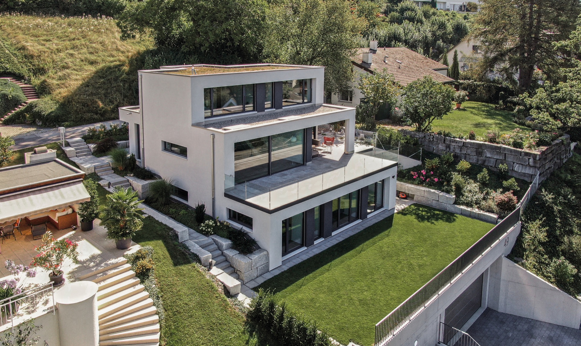 Luftaufnahme eines modernen Einfamilienhauses mit Terrasse und Garten