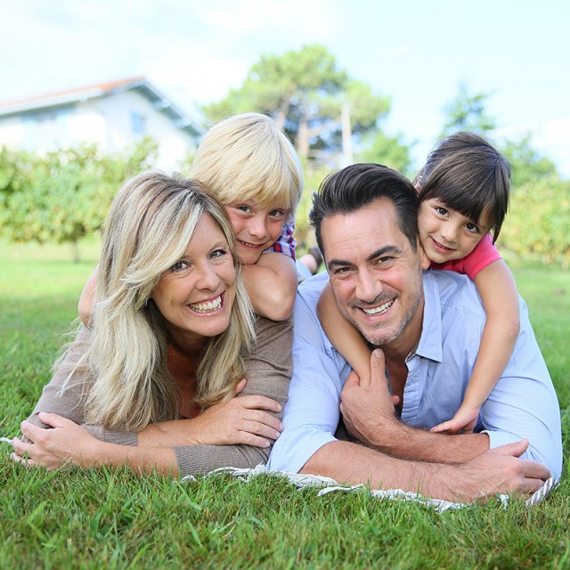 Glückliche Bauherrenfamilie im eigenen Garten.